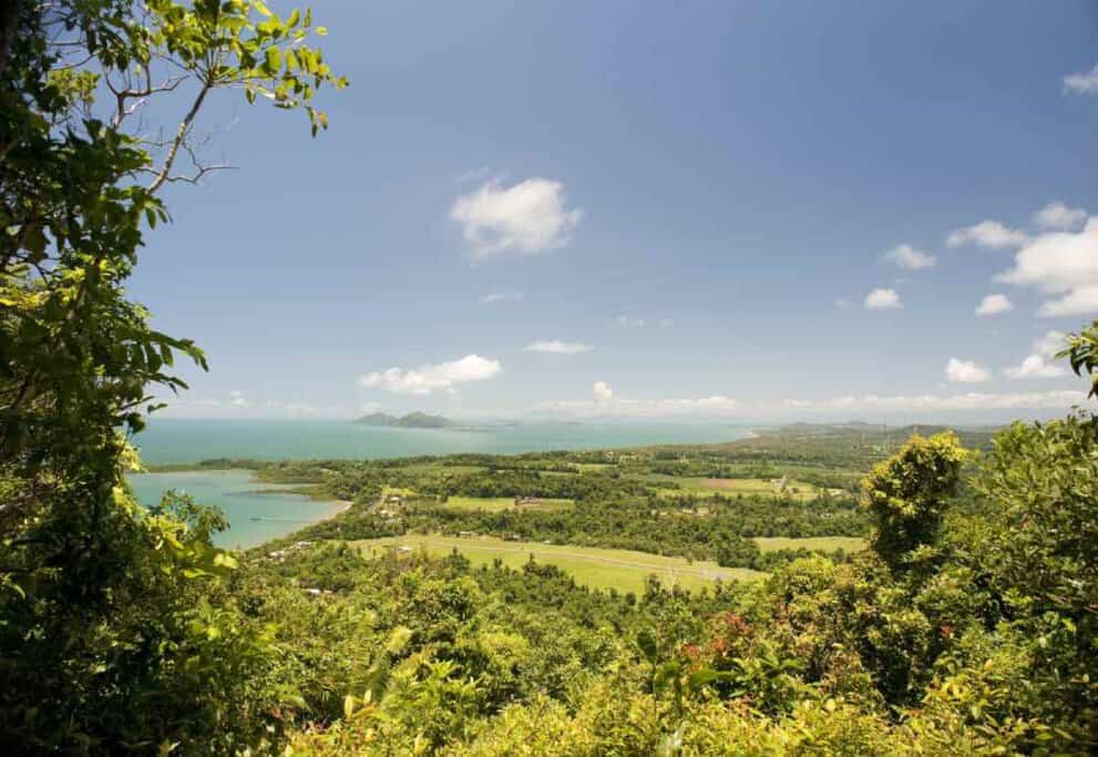 Panoramic view of lush greenery and coastline at Mission Beach in Queensland, Australia, under a clear blue sky. This image is part of a blog post about Australia travel deals, highlighting beautiful travel destinations.