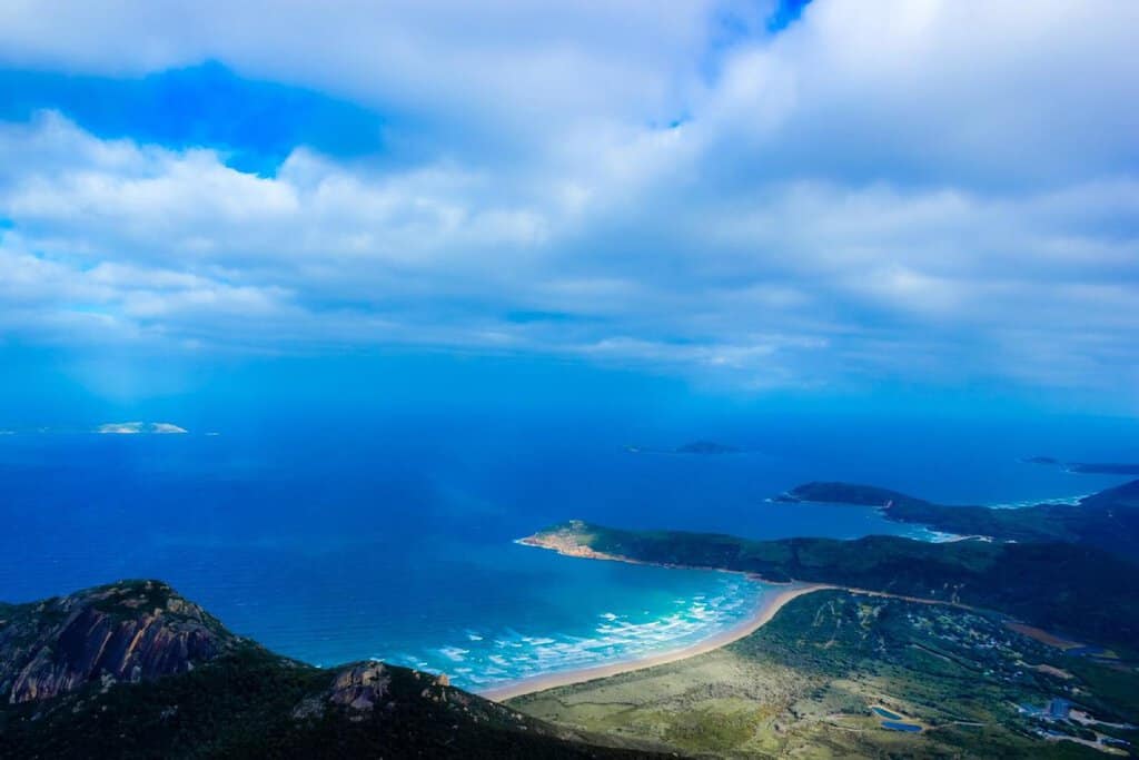 A breathtaking aerial view from Mount Oberon in Wilsons Promontory National Park, Victoria, Australia, showcasing a sweeping coastline, turquoise waters, and lush green headlands. This iconic lookout is part of Victoria’s most spectacular coastal landscapes, offering panoramic views and scenic hiking trails.