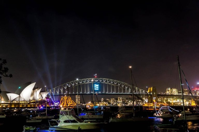 Sydney Opera House and Harbour Bridge illuminated during New Year's Eve, captured from Mrs. Macquarie's Point, a top spot for viewing the fireworks.
