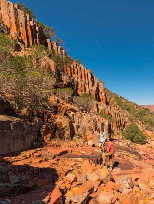 Two hikers explore the striking basalt columns of Organ Pipes National Park in Victoria, Australia. These unique rock formations, shaped by volcanic activity millions of years ago, make this park one of Victoria’s most fascinating geological wonders, perfect for nature walks and sightseeing.