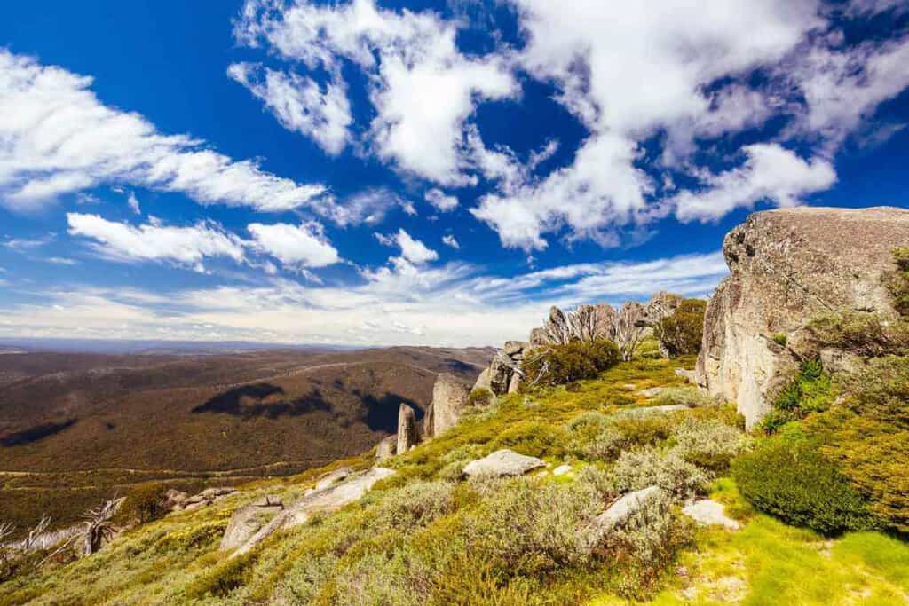Kosciuszko National Park, surrounded by vibrant alpine vegetation and dramatic skies, a striking feature along hiking trails in Victoria’s high country.
