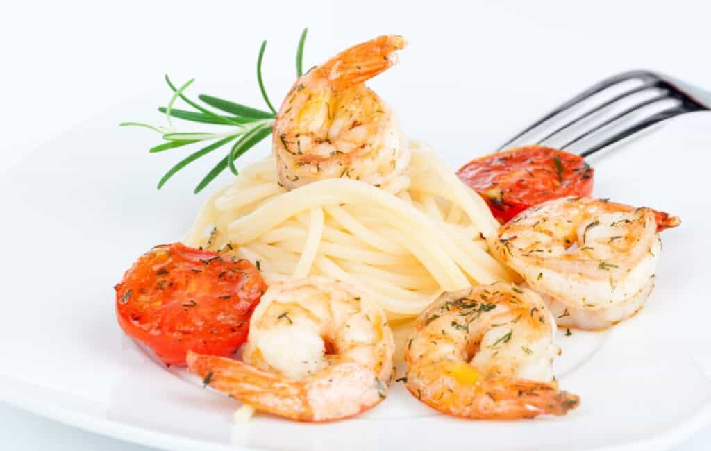 Plate of prawn linguine with grilled tomatoes and garnished with fresh herbs, served at Cheeky Dog, one of the best restaurants in Port Stephens. This seafood pasta dish highlights Cheeky Dog’s approach to Italian-inspired coastal cuisine, making it a go-to spot for seafood lovers visiting Port Stephens.