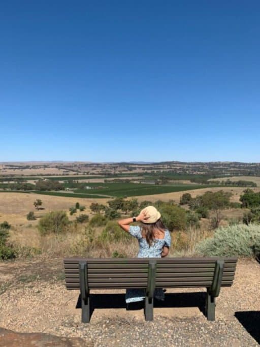 The author, Kate, sitting on a bench at Quarry Hill Lookout, contemplating the expansive landscape as one of the top things to do in Clare Valley, offering a moment of peace and panoramic views to visitors.