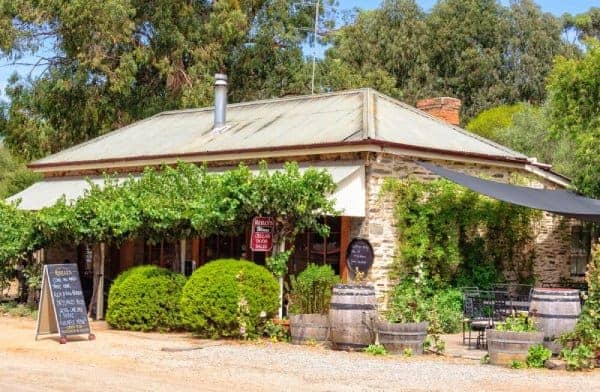 A rustic stone winery with a lush vine-covered entrance in Clare Valley, inviting visitors on Clare Valley Wine Tours to explore local wine offerings.