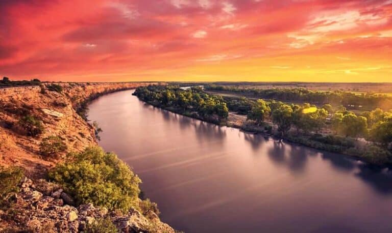 Dramatic sunset over River Murray with a rich tapestry of red and orange skies reflecting on the tranquil water, showcasing one of the major rivers mentioned in the blog post about the count of rivers in Australia.