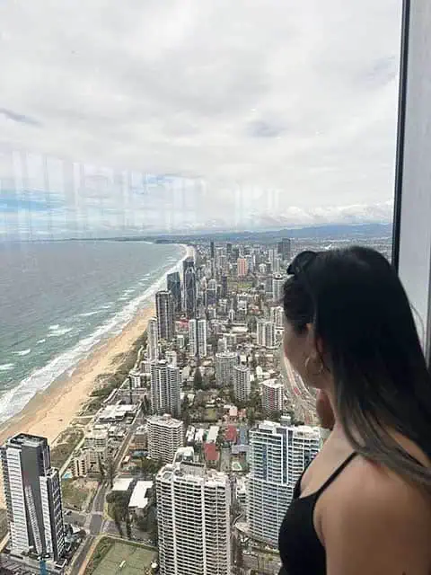 Kate gazes out from the SkyPoint Observation Deck at the expansive coastal and urban views, a must-visit on any Gold Coast itinerary.