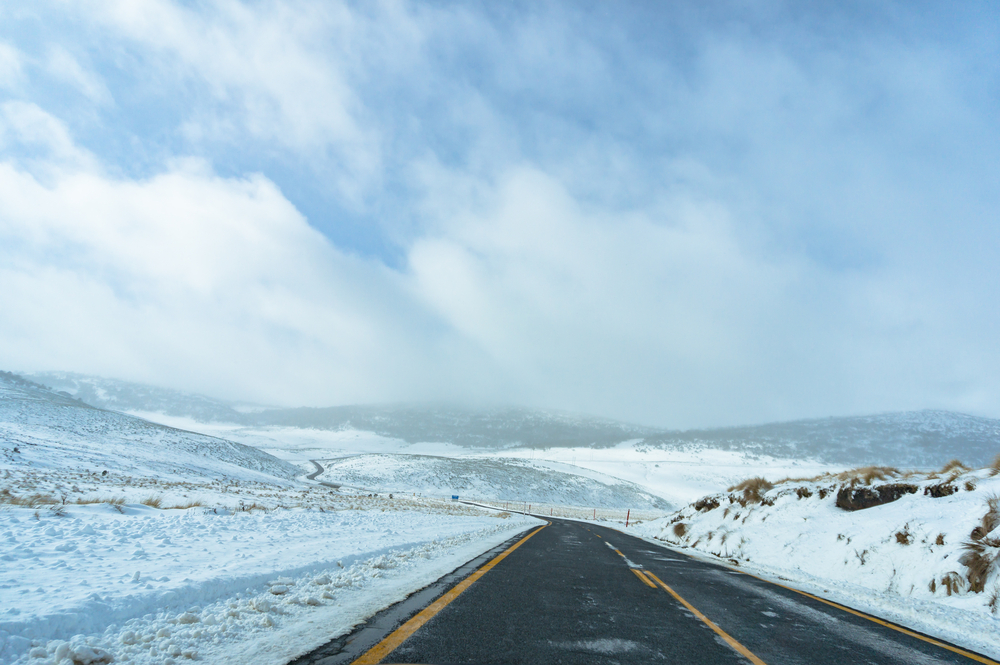 Australian winter landscape of snow covered fields and ice-covered road. Snowy Mountains, Australia