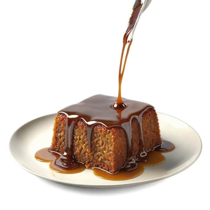 A slice of sticky date pudding drizzled with rich toffee sauce, a comforting dessert often enjoyed as part of Australia's Christmas food traditions.
