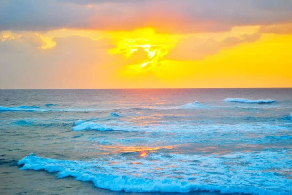 Golden sunset over the ocean waves along the Perth coastline, showcasing the natural beauty and serene beaches Western Australia is known for. This image connects to the blog post by illustrating why Perth's coastal views are a must-see for anyone debating whether Perth is worth visiting.