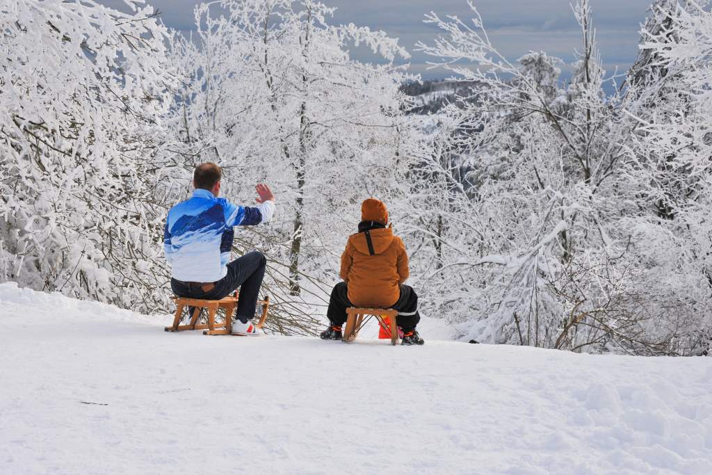 Two people riding the toboggan in the snow in Australia