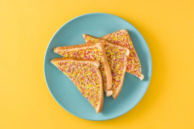 A plate of traditional Australian fairy bread, made with white bread, butter, and colourful sprinkles. This nostalgic and iconic Aussie treat is a favourite at children's birthday parties and celebrations.