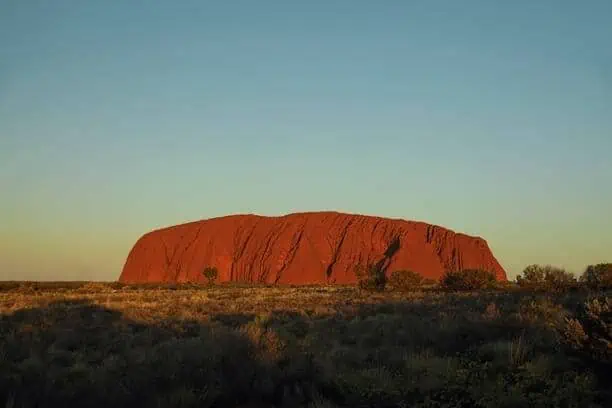 View of Uluru at sunset, showcasing the iconic and romantic landscape of Australia, perfect for honeymooners exploring the question: Is Australia a good place to spend a honeymoon?