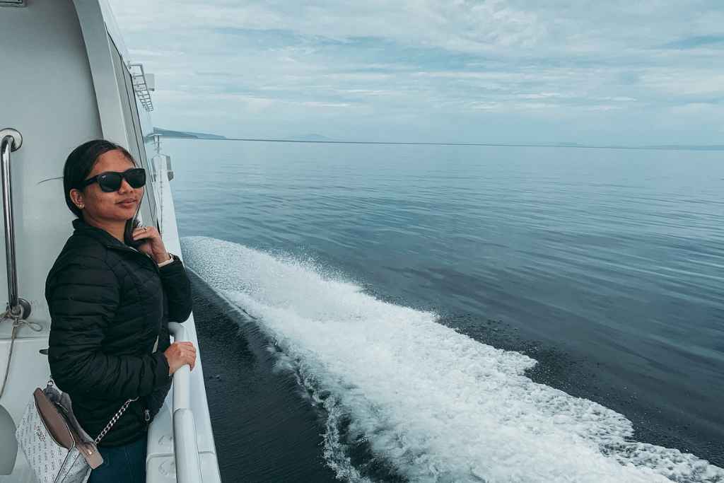 a picture of myself on the side railings of the boat during our wineglass bay cruise