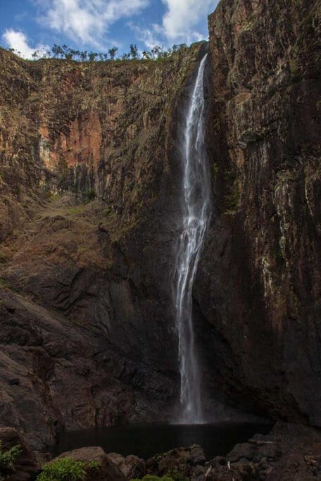 Wallaman Falls, Australia's tallest single-drop waterfall, cascading down rugged cliffs at Girringun National Park in Queensland. A stunning destination for outdoor adventure activities in Queensland, perfect for hiking and nature exploration.