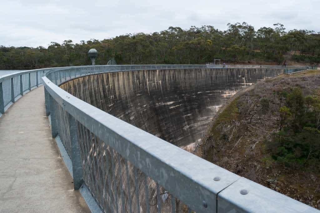 The Whispering Wall, a curved concrete dam in Barossa Valley, surrounded by forested areas, offering a unique acoustic experience and scenic views, one of the must-try activities in Barossa Valley.