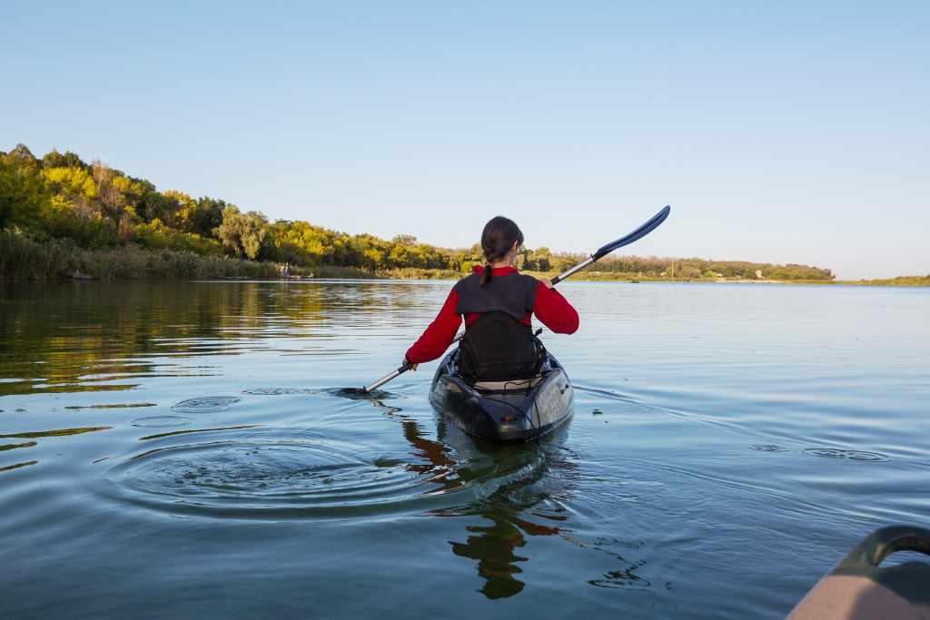 A woman kayaking towards an island